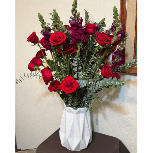 Florero con rosas, perrito y follaje